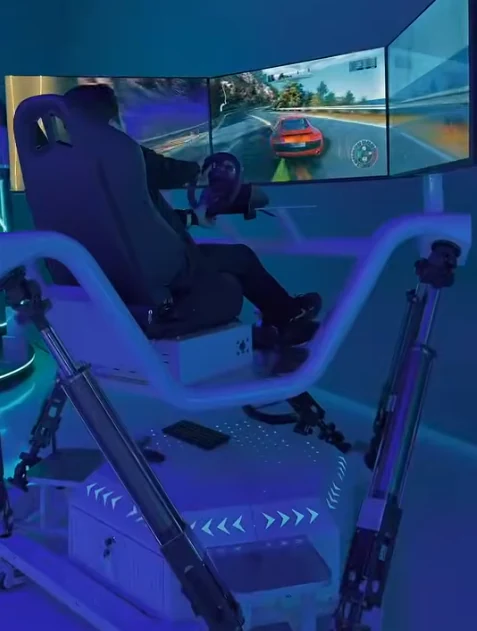 Visitor using a three-screen racing simulator at the Duhok entertainment center